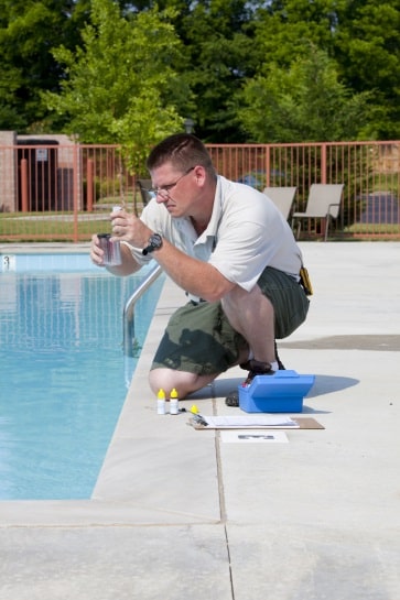 man testing swimming pool water